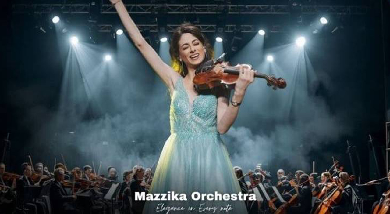 Violoniste du Mazzika Orchestra en robe turquoise, bras levé sur scène devant l orchestre